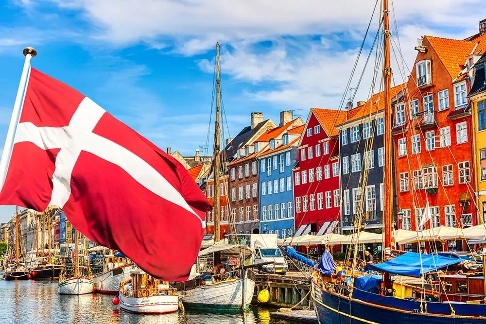 Garsusis senasis Nyhavn uostas Kopenhagos centre, Danija su Danijos vėliava priešakyje 